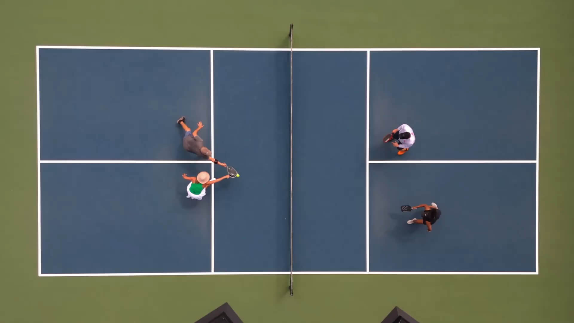 Aerial view of doubles pickleball game in action at Village Clubs Camelback, featuring blue and green courts in Arizona.