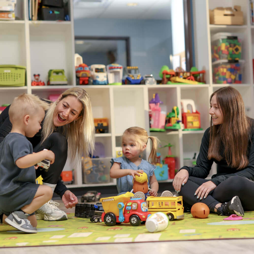 Families enjoy playtime with toys and games at Village Clubs' bright, organized kids' room at Camelback in Arizona.