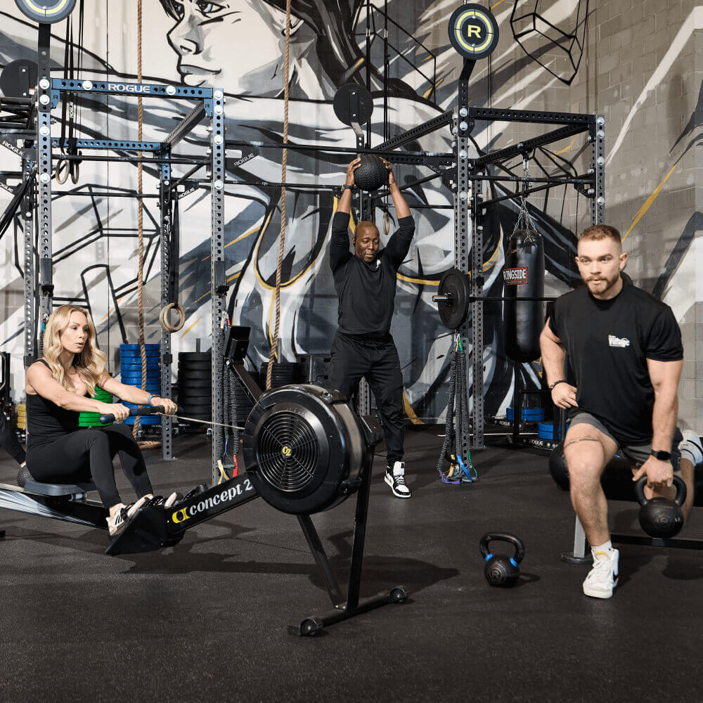 Members exercise at Village Clubs Camelback: rowing, medicine ball lifts, and kettlebell lunges with gym equipment in view.