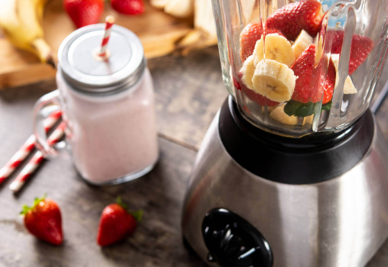 A Village Clubs blender at DC Ranch filled with fresh strawberries and bananas, ready for a healthy smoothie preparation.