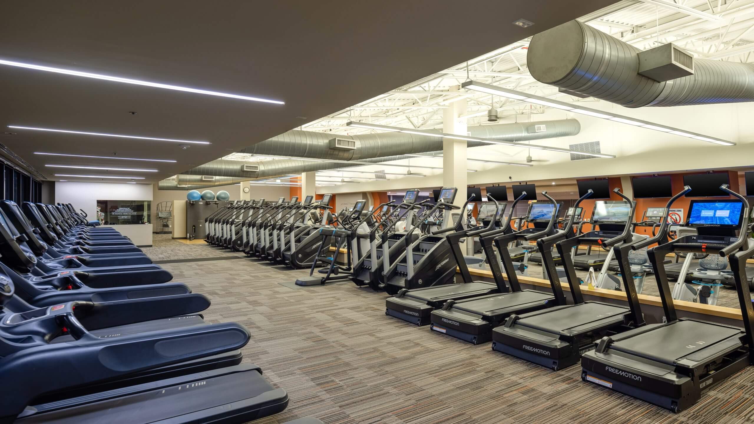 Village Clubs at Ocotillo offers a bright, modern gym with treadmills, ellipticals, and bikes facing mirrors for your workout.