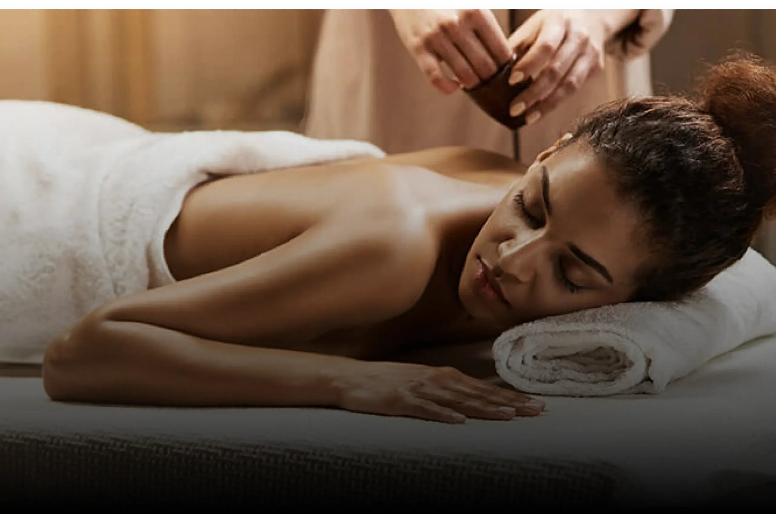 At Village Clubs Camelback in Arizona, a woman relaxes face-down as a masseuse prepares to apply oil during her massage.
