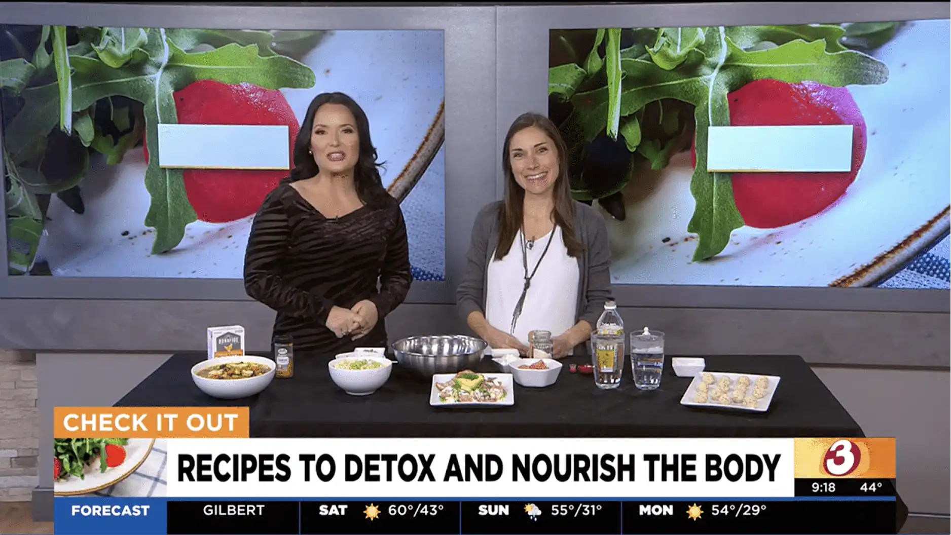At Village Clubs DC Ranch, two women showcase healthy recipes on a TV set with salad images and a wellness-themed news ticker.