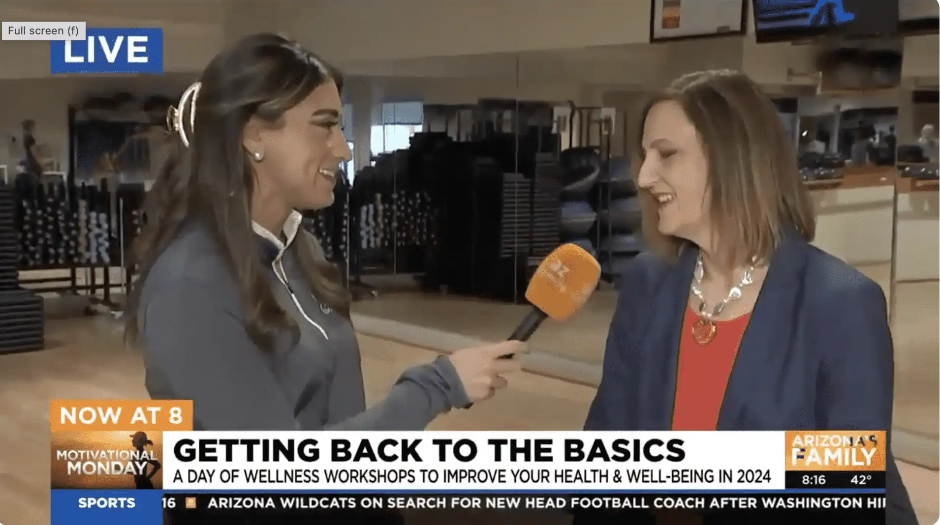 A reporter interviews a smiling woman at Village Clubs Camelback gym as Back to the Basics wellness workshops are promoted on TV.