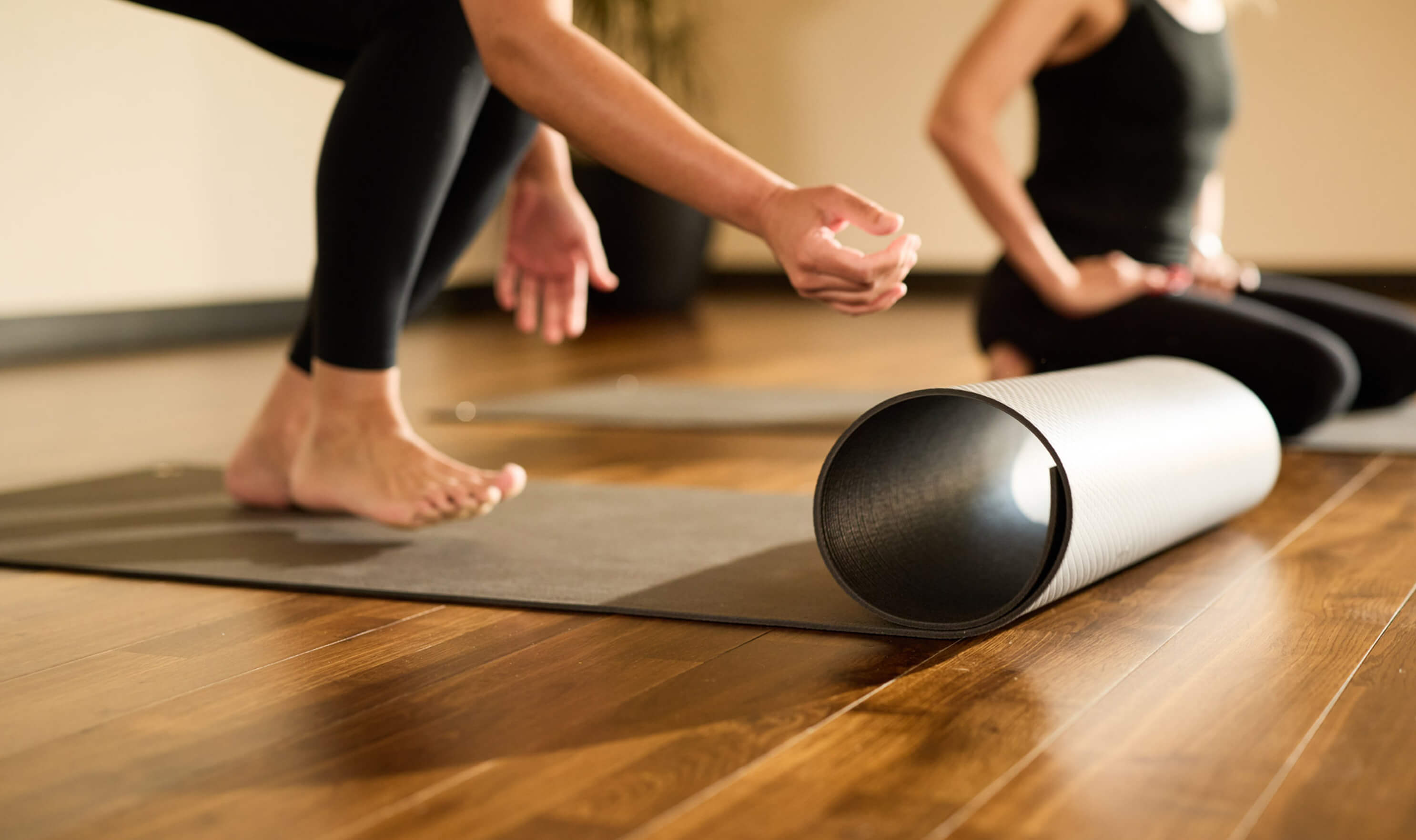 Guests stretch on yoga mats at Village Clubs Camelback, enjoying an indoor fitness session in a well-lit studio.
