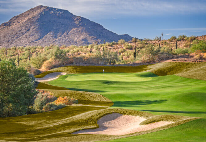 Village Clubs at DC Ranch features lush fairways, sand bunkers, and desert views with mountains under a bright Arizona sky.