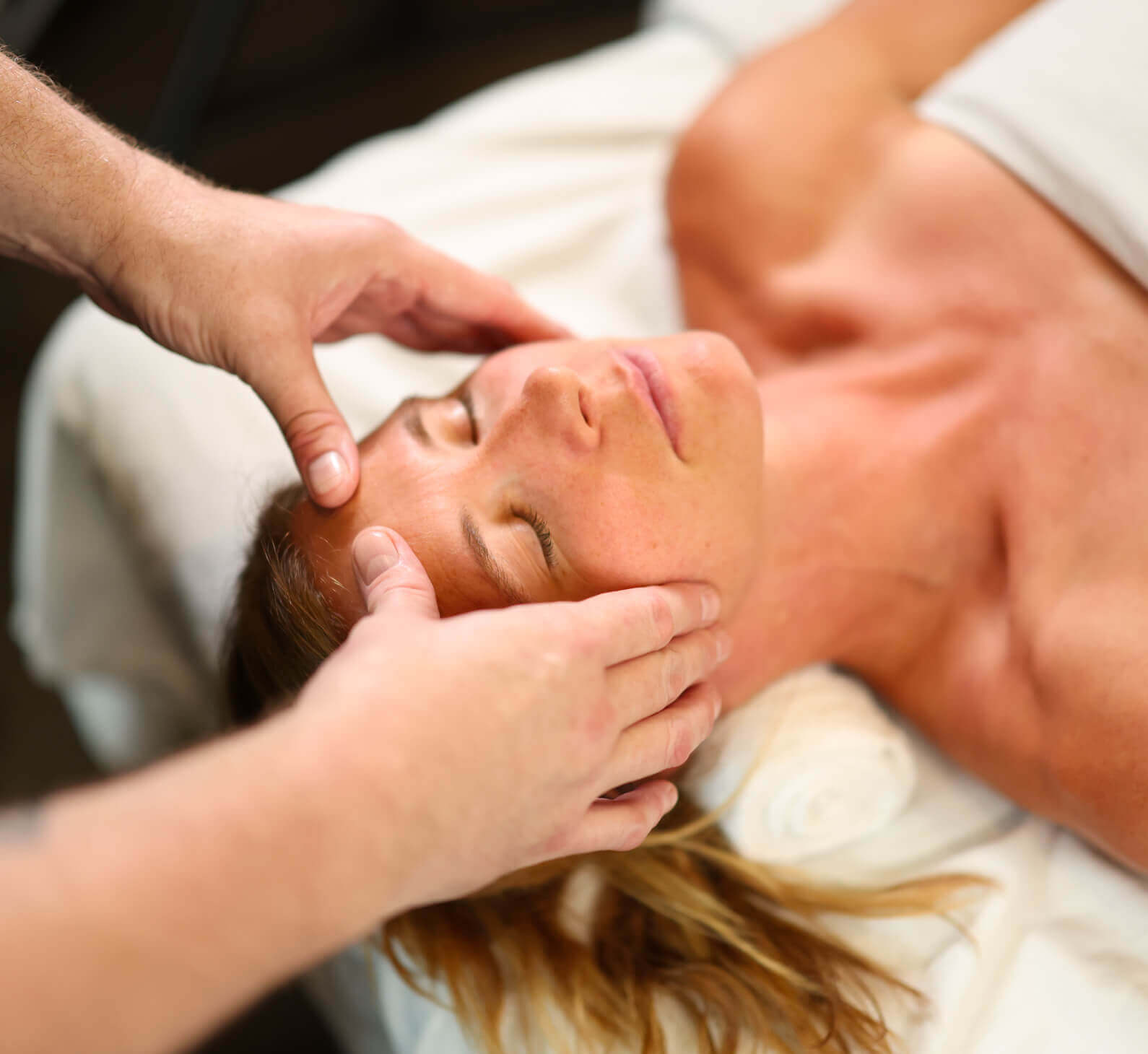 A person enjoys a relaxing facial massage at Village Clubs Camelback in Arizona, highlighting the spa’s tranquil self-care experience.